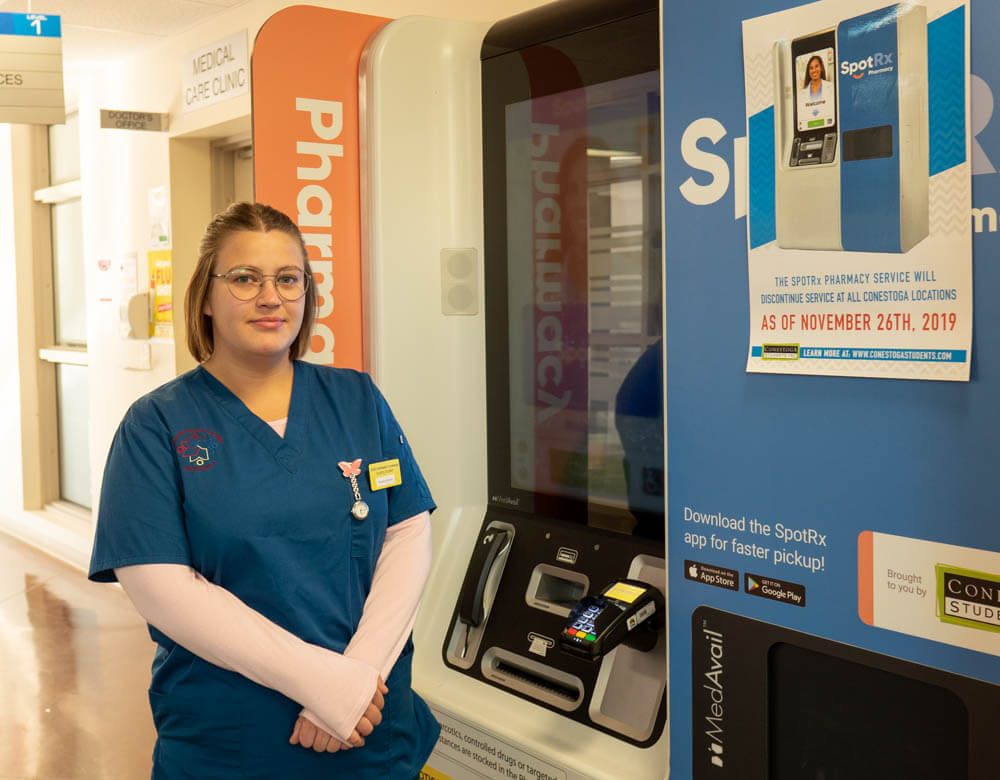 Nursing student Elizabeth Murley stands by a SpotRx pharmacy machine on Conestoga College's Doon campus on Nov. 5, 2019.