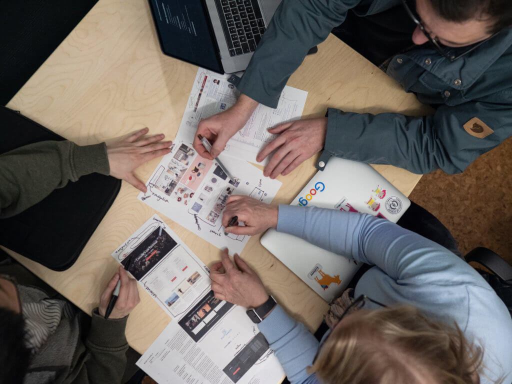 Three people work on an activity at a table that helps them understand web accesibility.