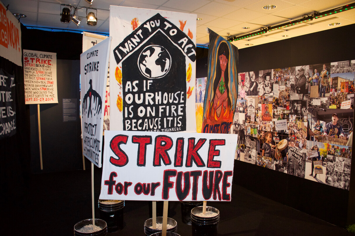 Climate Action display at SPECTRUM: picket signs and climate strike photos