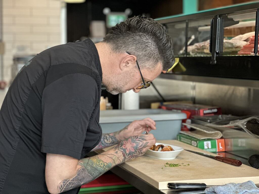 Wood takes his craft seriously. When putting orders together, he takes his time. He will garnish an order with chopped scallions piece by piece if he has to. Photo by John Dalusong